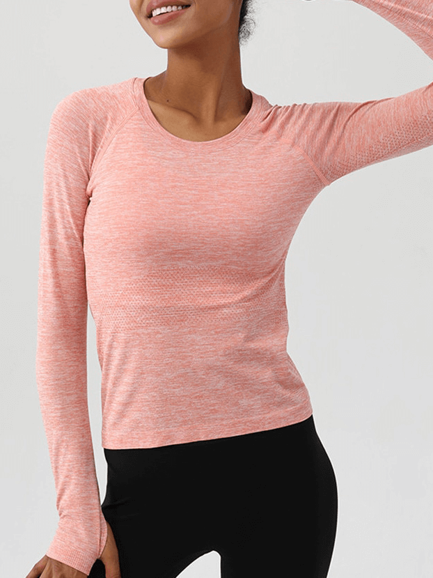 Woman wearing peach long-sleeve yoga shirt with thumbs, round neck, perfect for fitness. SF1510